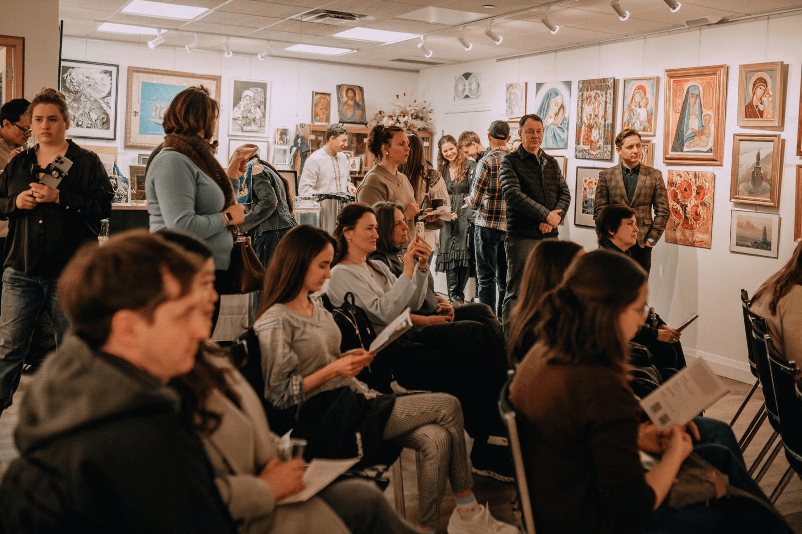 Community members gathered for a cultural and educational event in an art gallery.